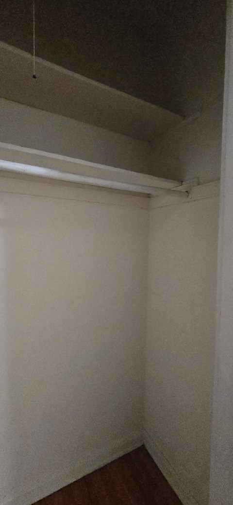 A white wall with a brown floor.