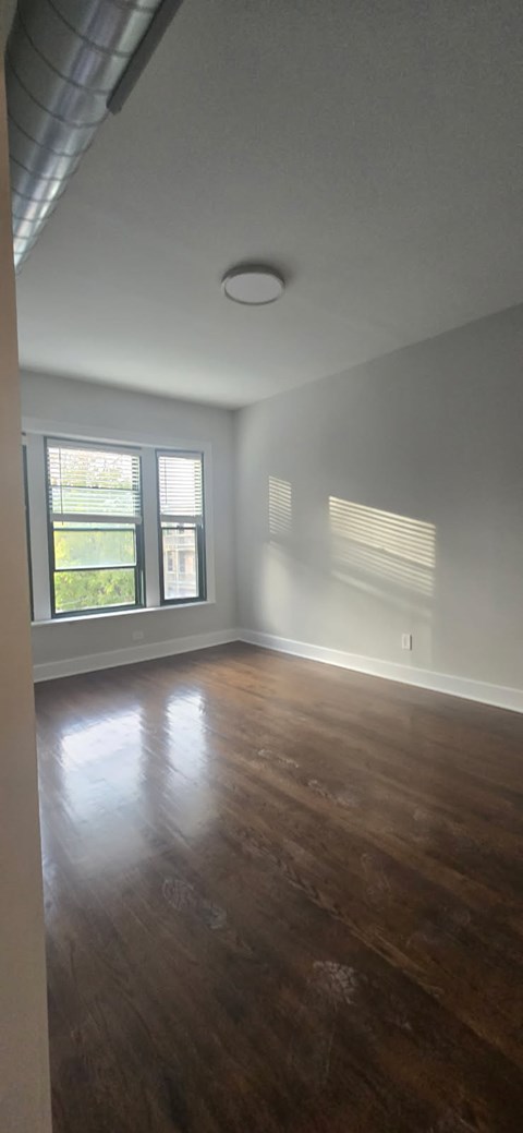 A room with wooden floors and a window letting in light.