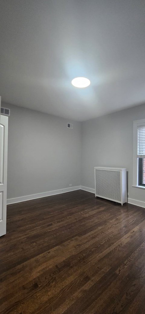 A room with a white ceiling and a window with blinds.