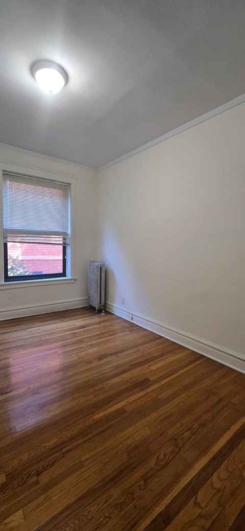 A room with wooden floors and a window.