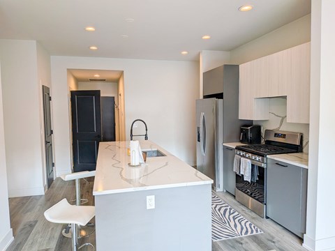 A kitchen with a white counter and a black fridge.
