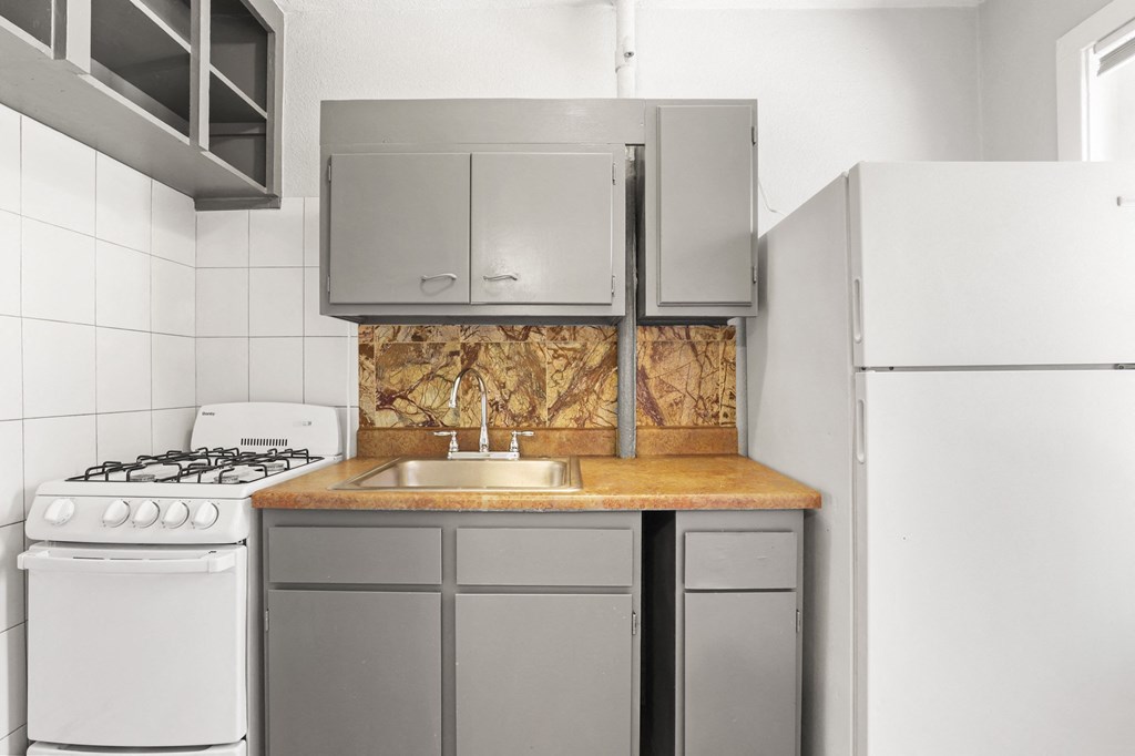 an empty kitchen with a sink and a refrigerator