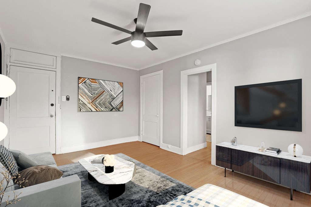 a living room with a ceiling fan and a tv