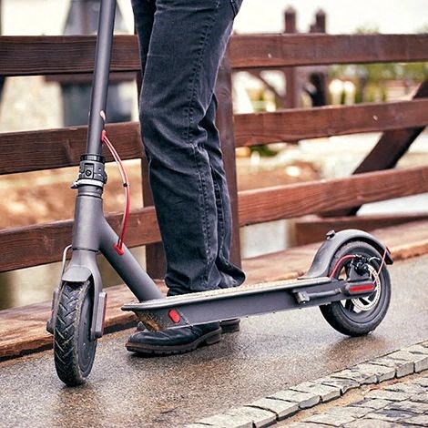 a person is standing next to a scooter