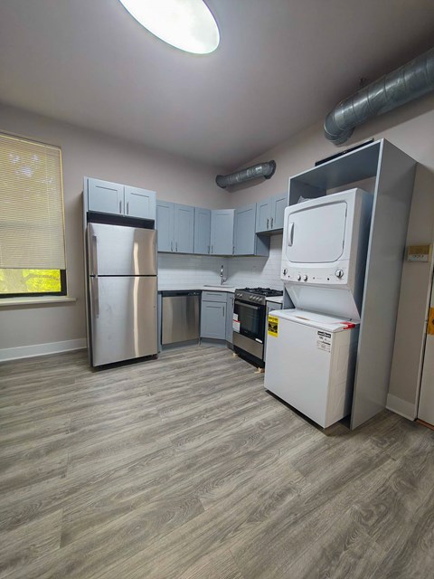 A kitchen with a refrigerator, oven, and microwave.