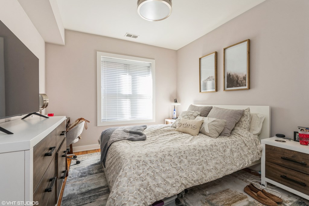a bedroom with a bed and a desk and a window