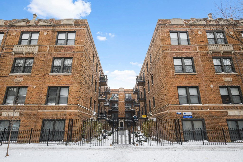 a pair of tall brick buildings with snow on the ground