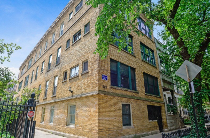 a large brick building with a tree in front of it