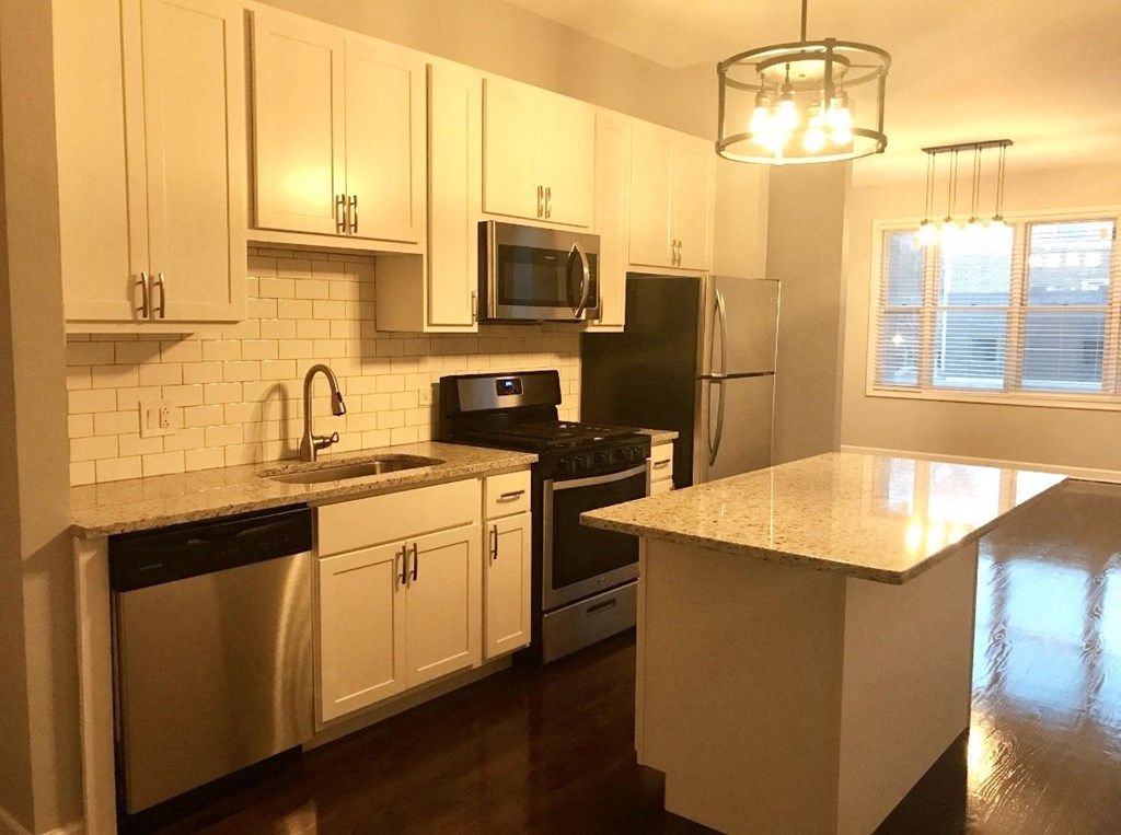 a kitchen with stainless steel appliances and white cabinets