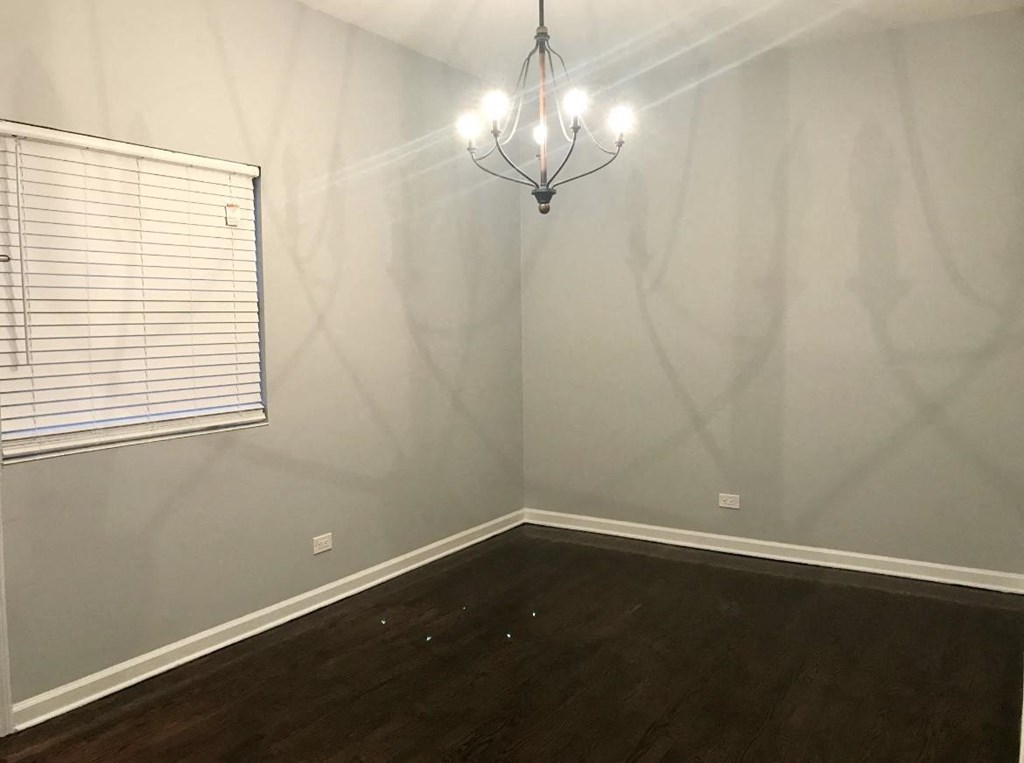a empty room with a window and a chandelier