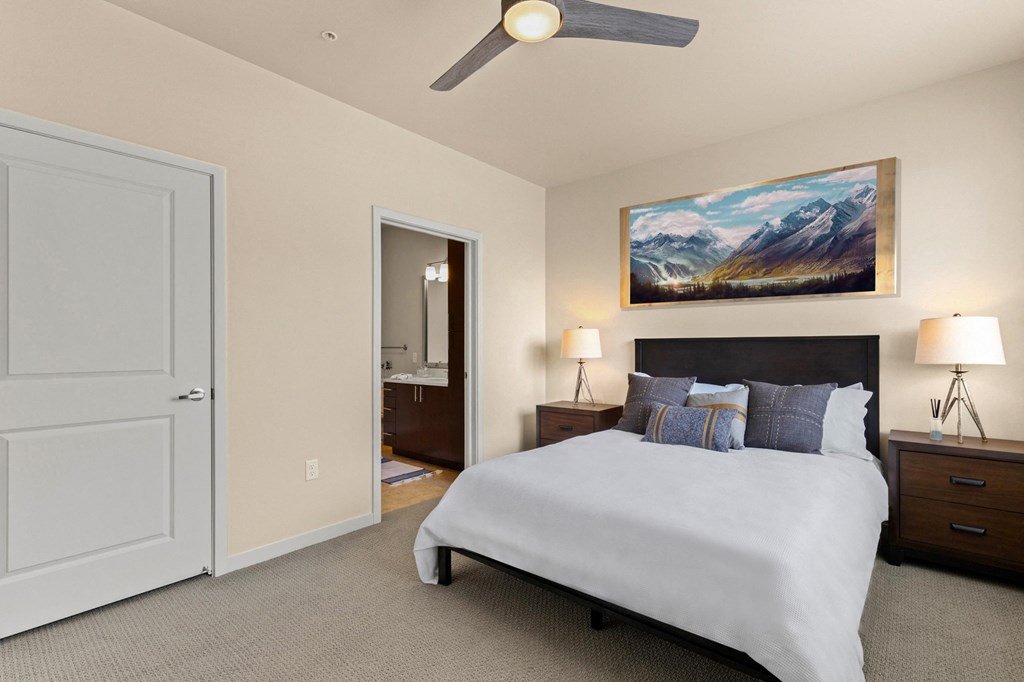 a bedroom with a white bed and a ceiling fan