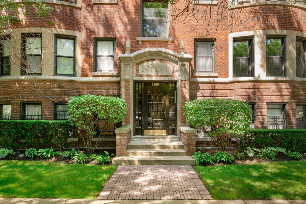 the front of a red brick house with a golden door