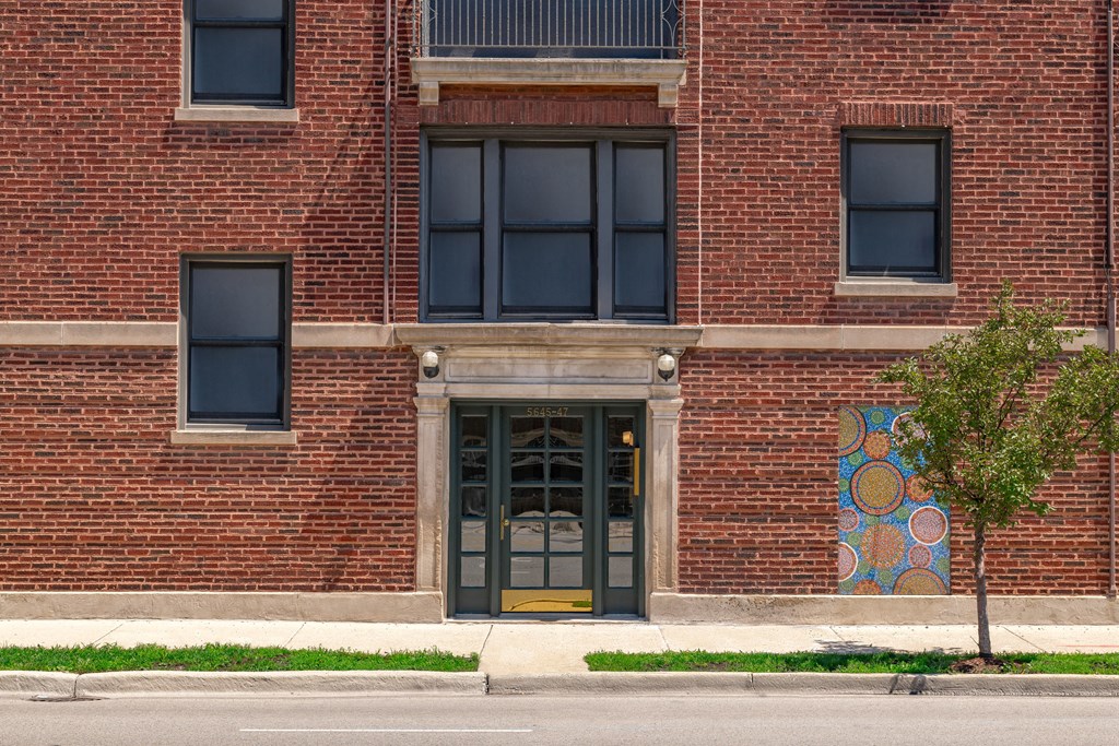 the entrance to a brick building with a yellow door