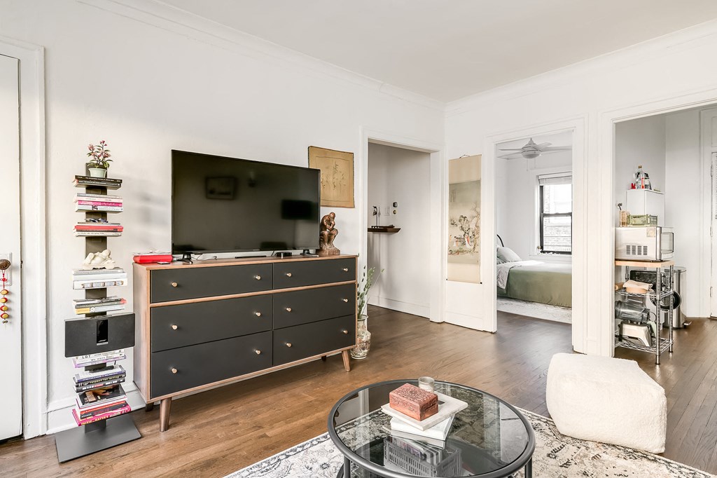 a living room with a dresser and a tv    and a table