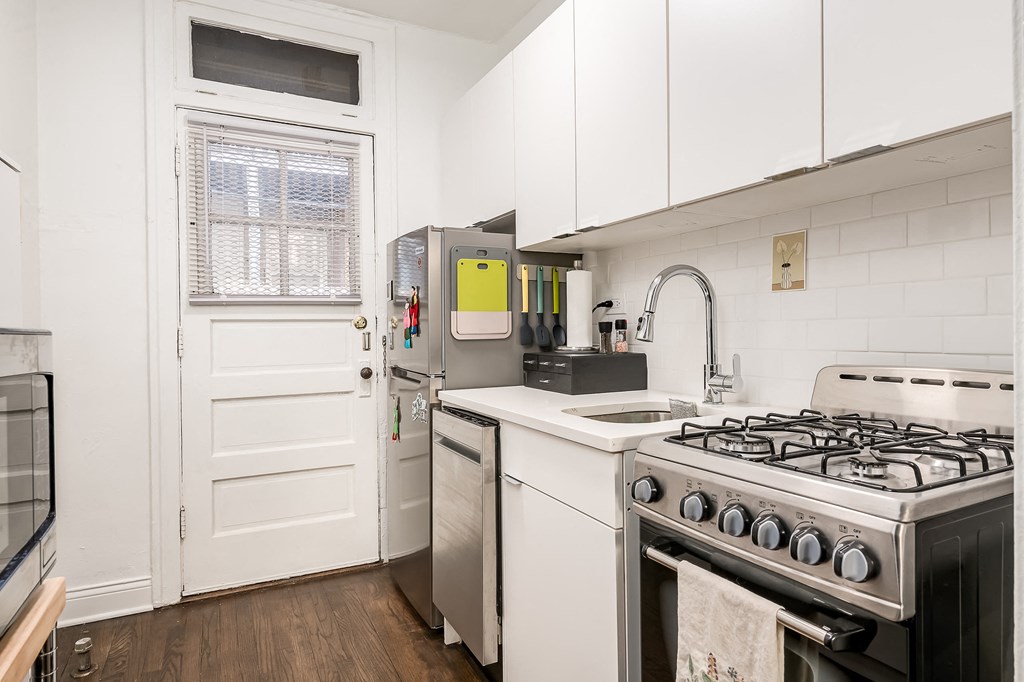 a kitchen with white cabinets and a stove and a refrigerator