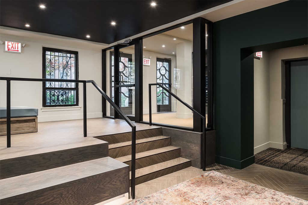 the lobby of a building with stairs and a glass door