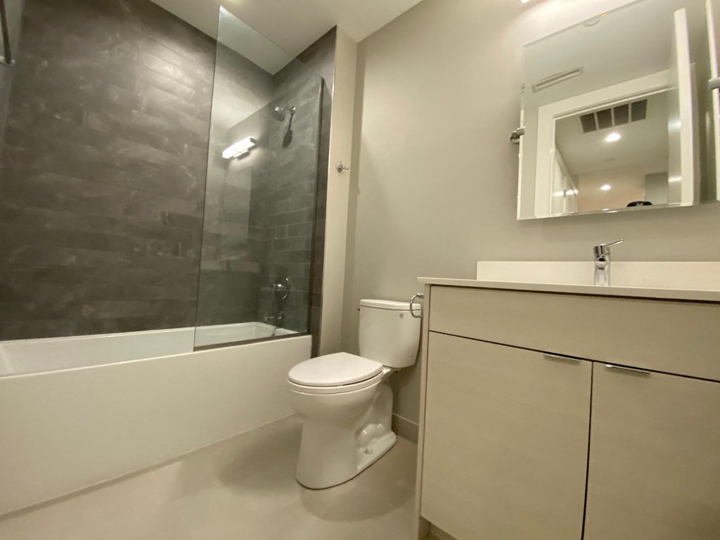 a bathroom with a toilet and a shower and a sink