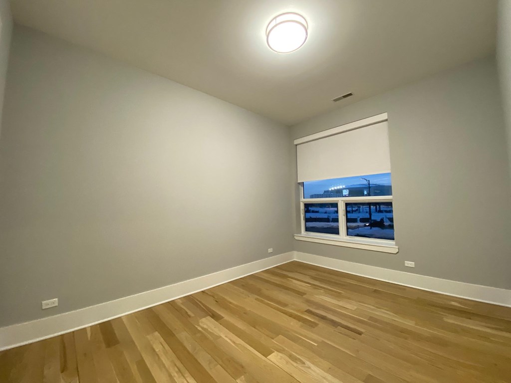 a living room with wood flooring and a window
