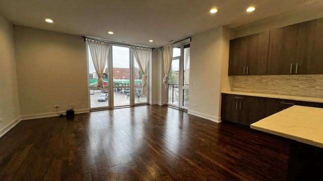 an empty living room with wood floors and a balcony