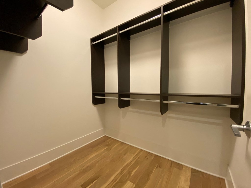 a room with wooden floors and white walls with a tv on the wall