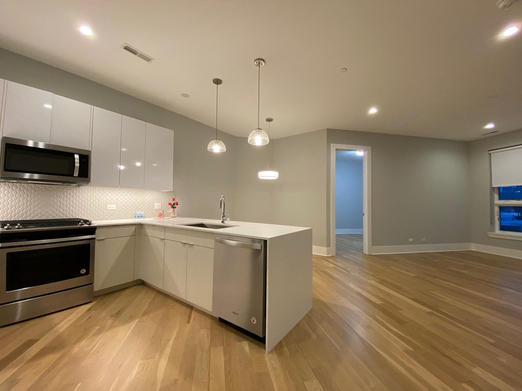 a renovated kitchen with white cabinets and stainless steel appliances