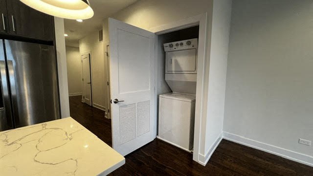 a small kitchen with a refrigerator and a white door