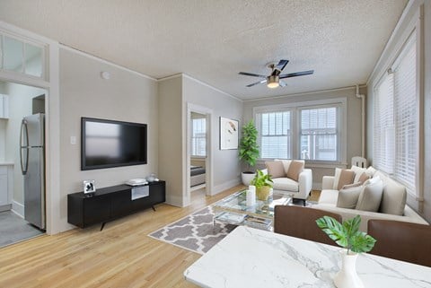 a living room with a ceiling fan and a tv
