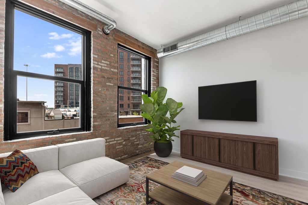 A living room with a white couch, a wooden coffee table, and a flat screen TV mounted on the wall.