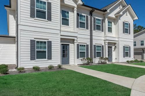 a white house with green grass and a sidewalk
