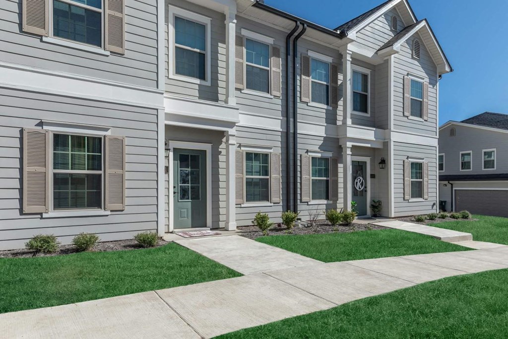 a white house with a sidewalk in front of it