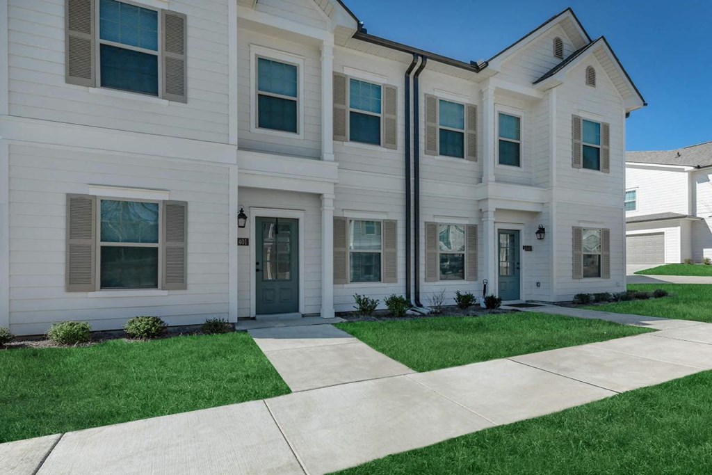 a white house with a sidewalk in front of it
