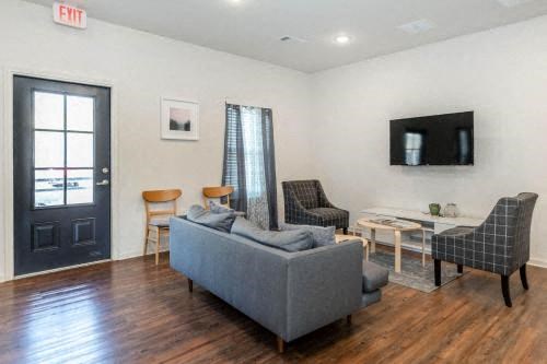 a living room with a couch and chairs and a television