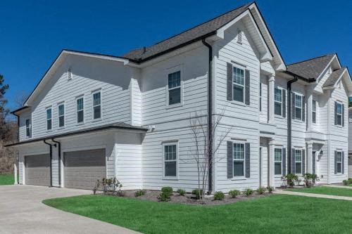 a white house with a driveway and a lawn