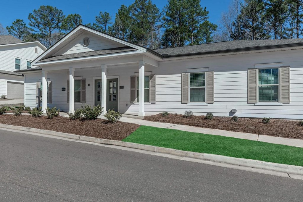 a white house with a lawn and sidewalk in front of it