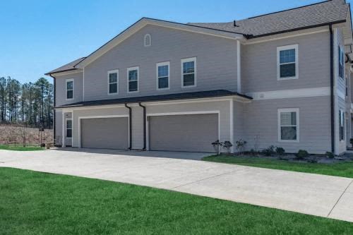 a house with two garage doors on a sidewalk