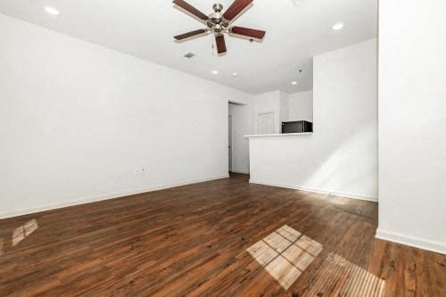a empty living room with a ceiling fan