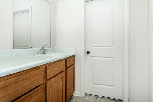 a bathroom with a sink and a white door