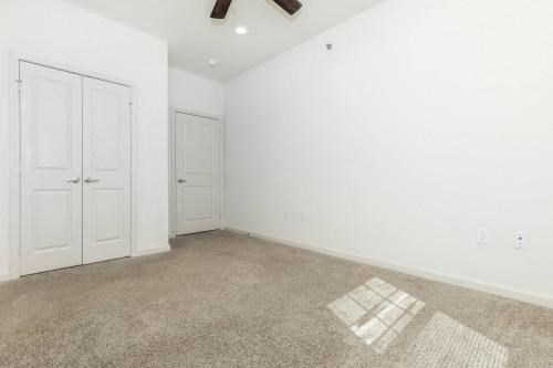 an empty room with a door and a ceiling fan