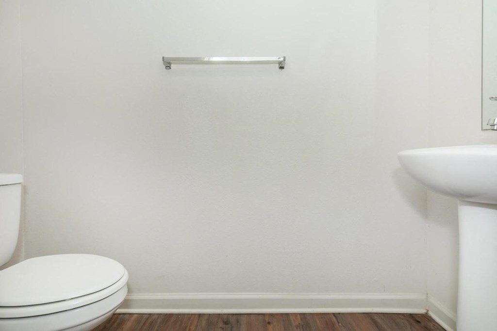 a white bathroom with a toilet and a sink