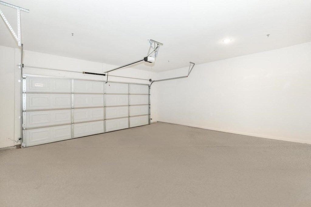 an empty garage with a white wall and a garage door
