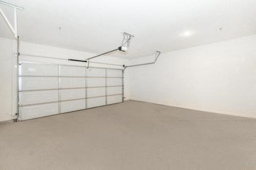 an empty garage with a white wall and a white garage door