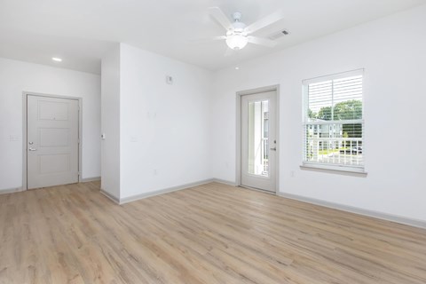 A room with a ceiling fan and two doors.