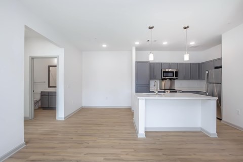 A kitchen with a white island and wooden floors.