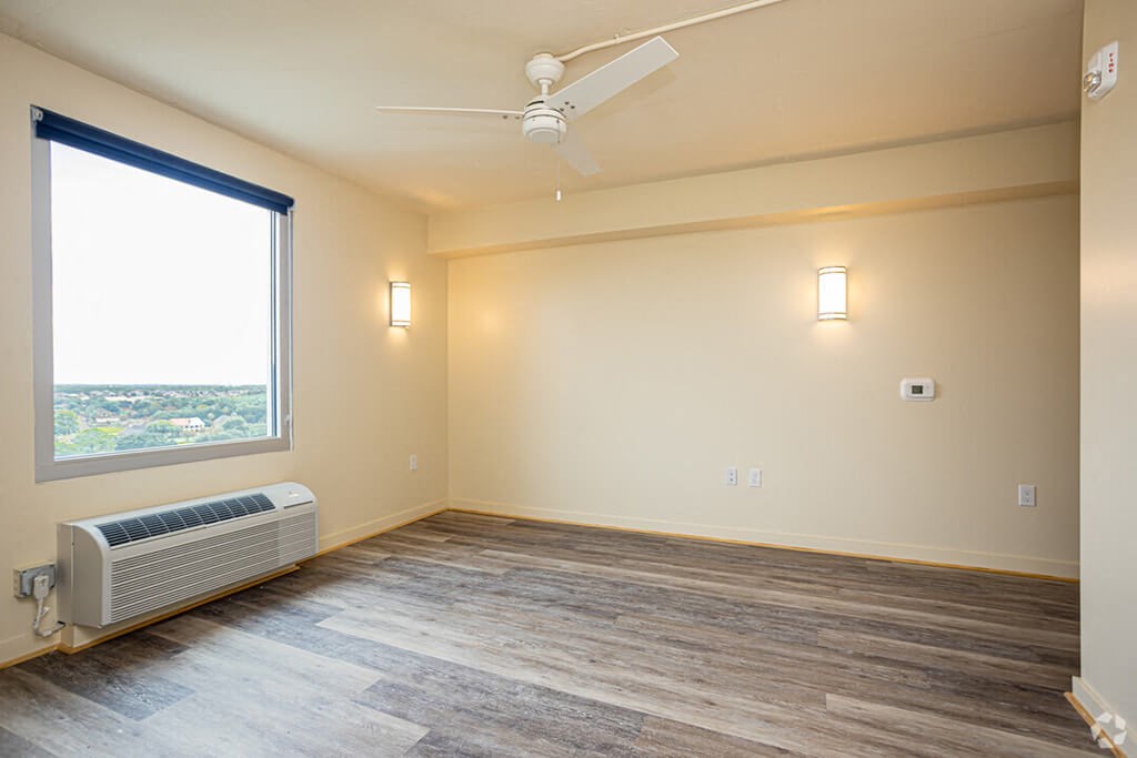 a living room with wood floors and a window and a ceiling fan