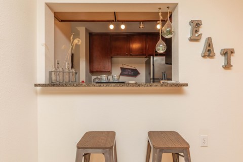 A kitchen with a counter and two stools.