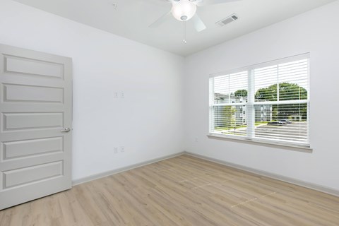 A room with a white door and a window with blinds.
