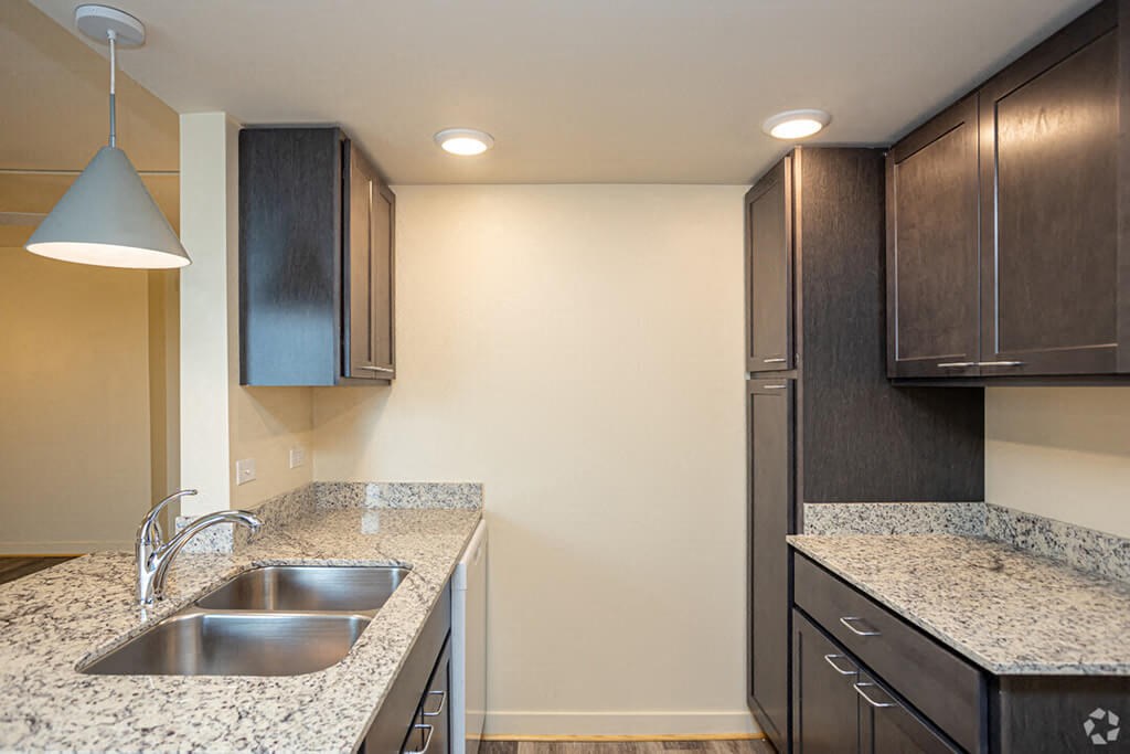 a kitchen with granite counter tops and a stainless steel sink