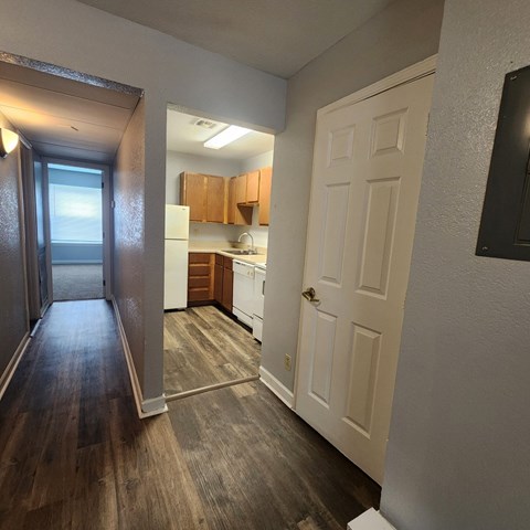 A kitchen with white appliances and wooden cabinets.