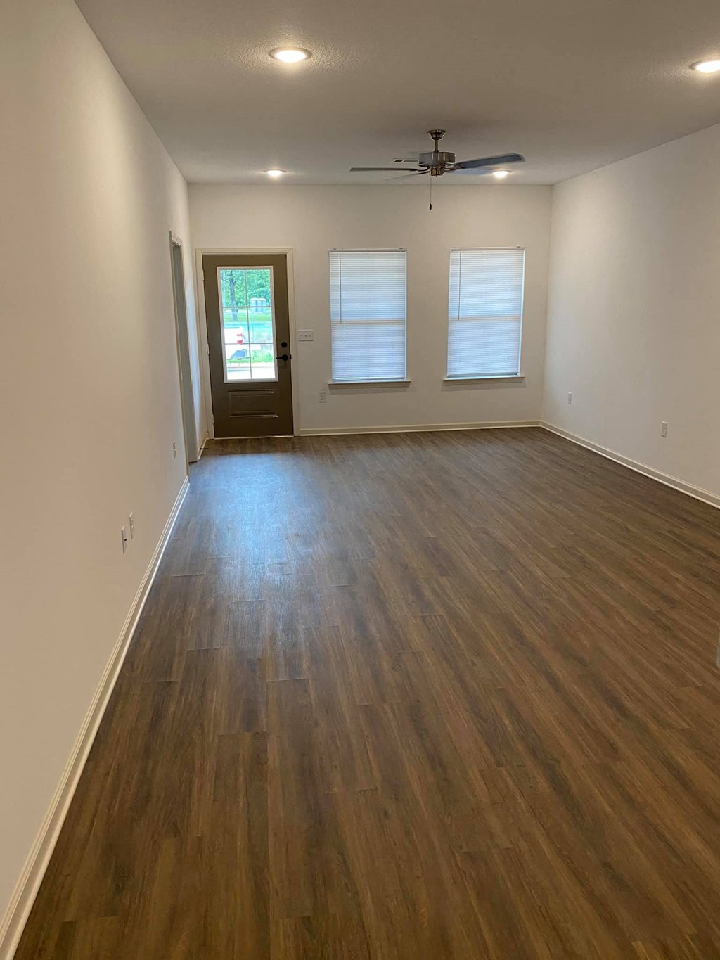 an empty living room with a hard wood floor