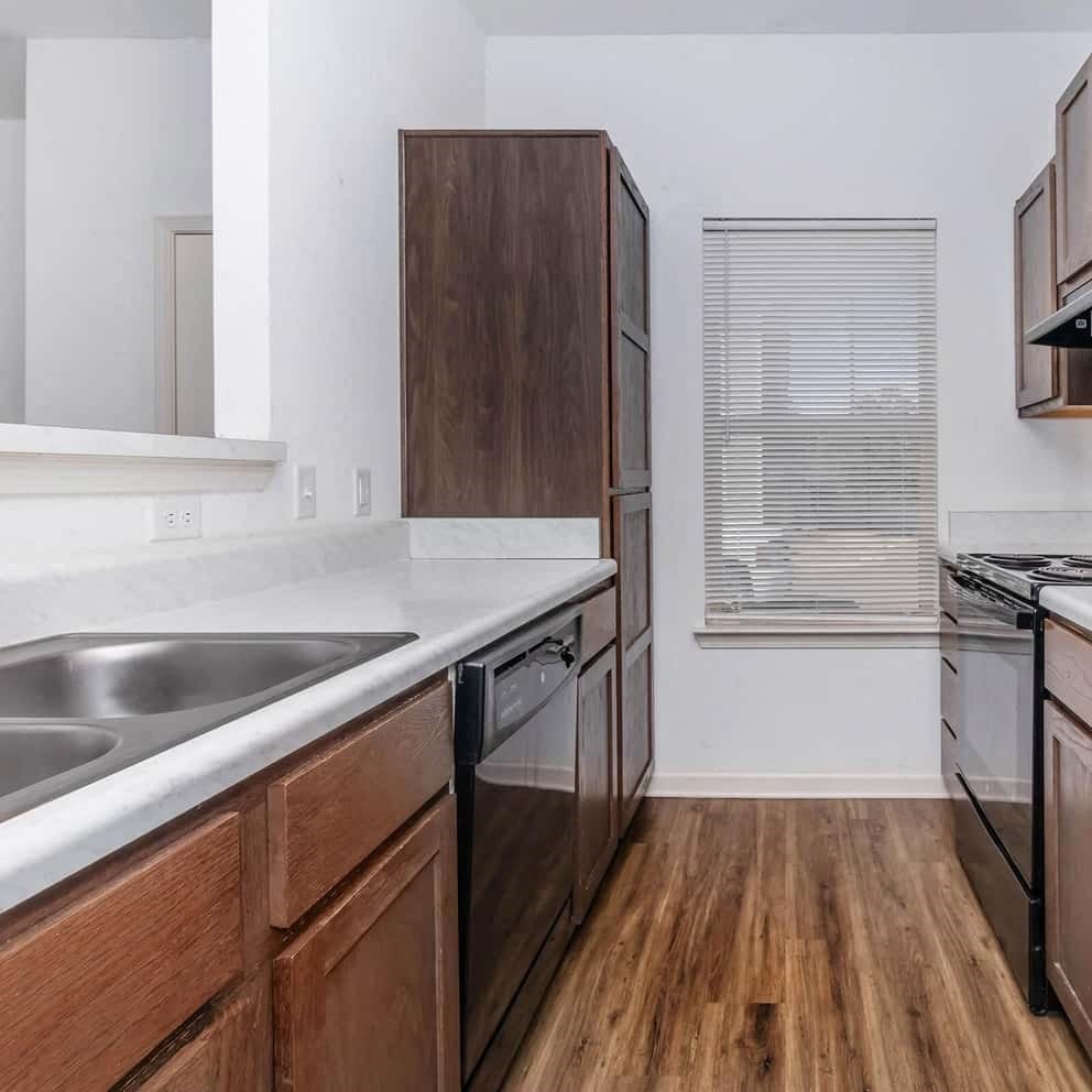 an empty kitchen with a sink and a refrigerator